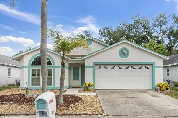 a view of a brick house with large windows and a table and chairs