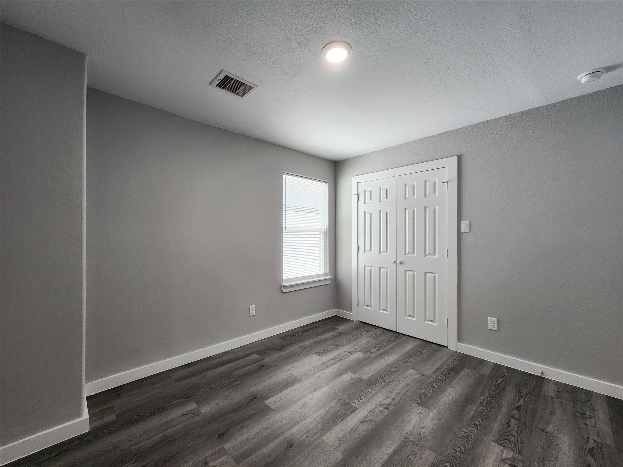 7735 Orebo Street, Unit B Houston, TX 77088 - Photo 11 of 14 an empty room with wooden floor and windows