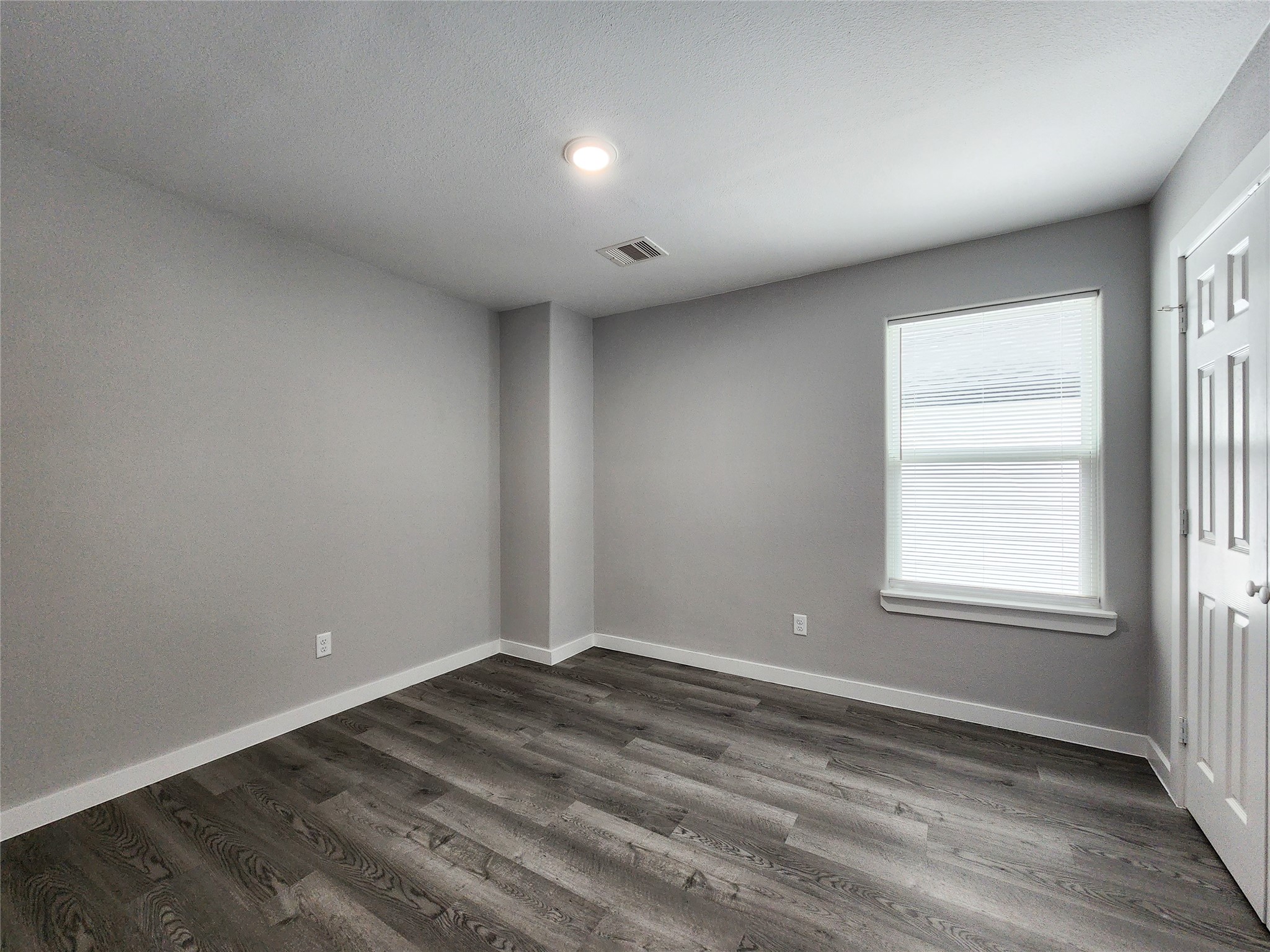 7735 Orebo Street, Unit B Houston, TX 77088 - Photo 8 of 14 an empty room with wooden floor and windows