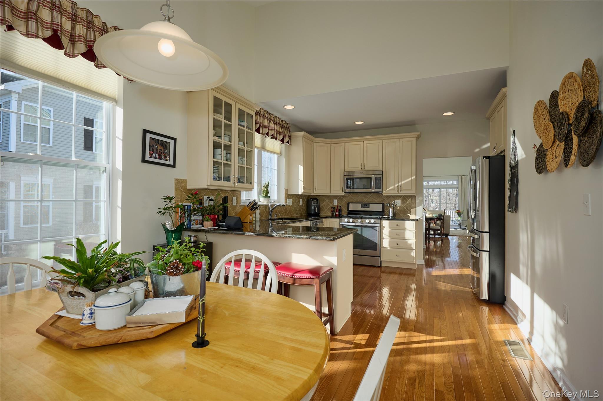 40 Evan Court Fishkill, NY 12508 - Photo 12 of 49 a kitchen with a refrigerator a stove and a dining table with wooden floor