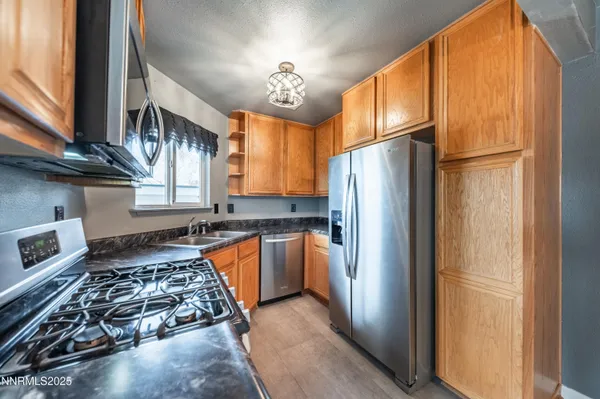 a kitchen with stainless steel appliances granite countertop a refrigerator and a stove