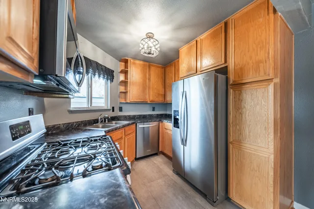 a kitchen with stainless steel appliances granite countertop a refrigerator and a stove