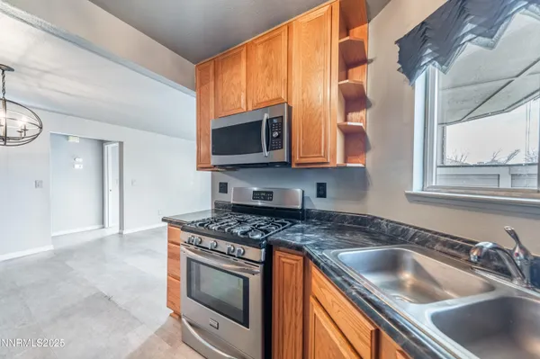a kitchen with granite countertop a sink a stove and microwave