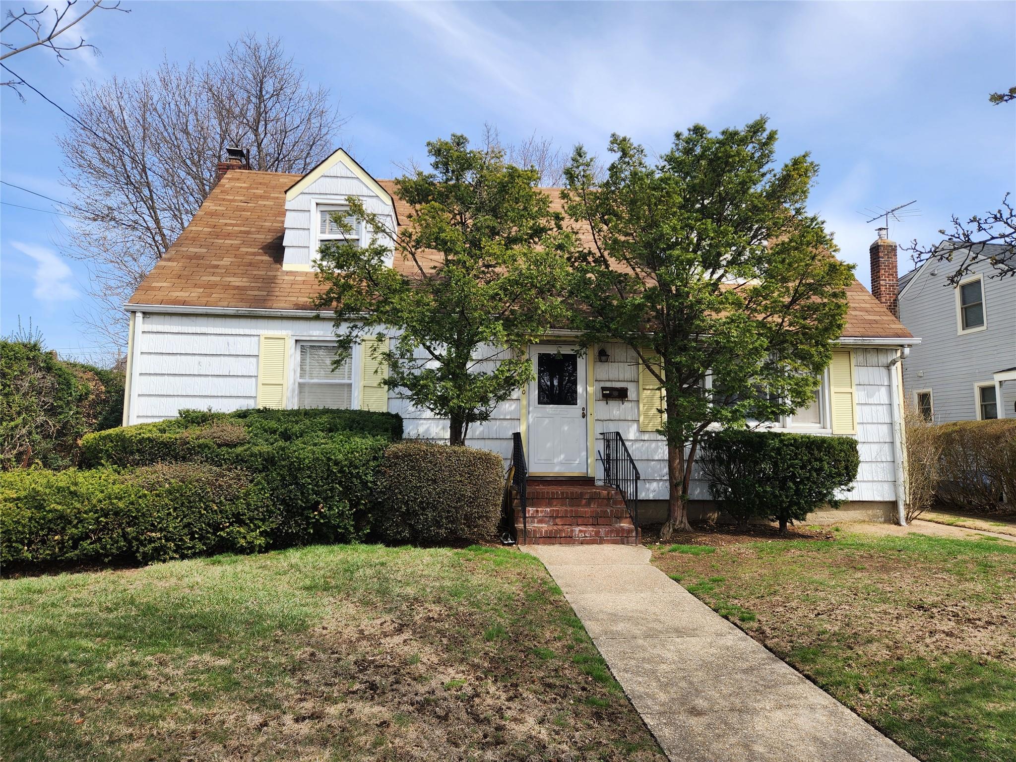 70 Lincoln Road Hempstead, NY 11550 - Photo 1 of 1 View of front of house with a chimney and a front lawn