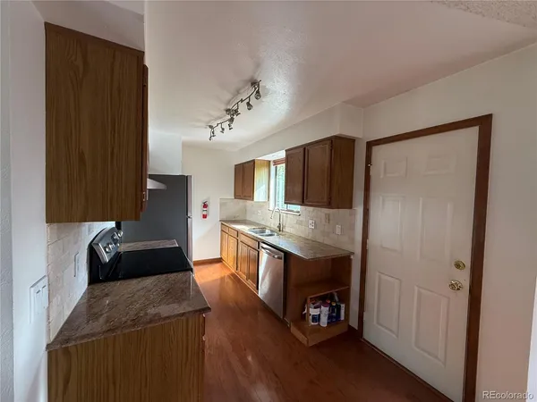 a kitchen with a sink a refrigerator and window