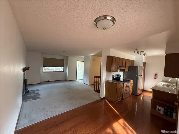 a kitchen with stainless steel appliances granite countertop a refrigerator a stove a sink and dishwasher