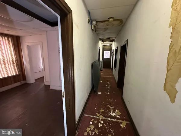 a hallway with wooden floor windows and stairs