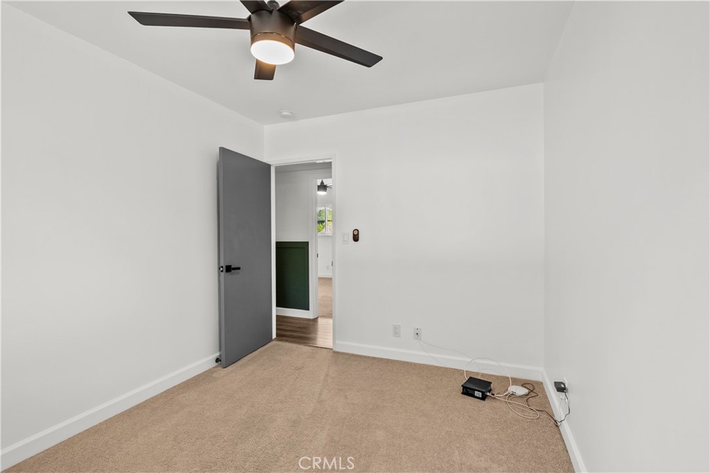 25083 Wheeler Road Newhall, CA 91321 - Photo 24 of 46 an empty room with a ceiling fan and carpet