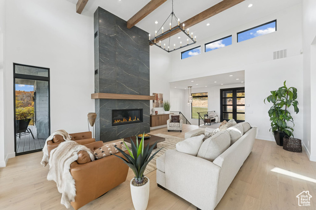 2280 East Outlaw Road, Unit 56 Kamas, UT 84036 - Photo 12 of 59 Living area featuring light wood finished floors, a fireplace, beamed ceiling, a towering ceiling, and recessed lighting