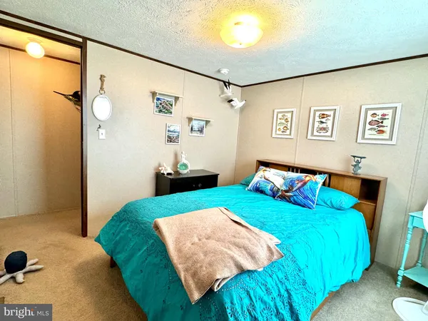 a bedroom with a bed and a flat tv screen on the dresser