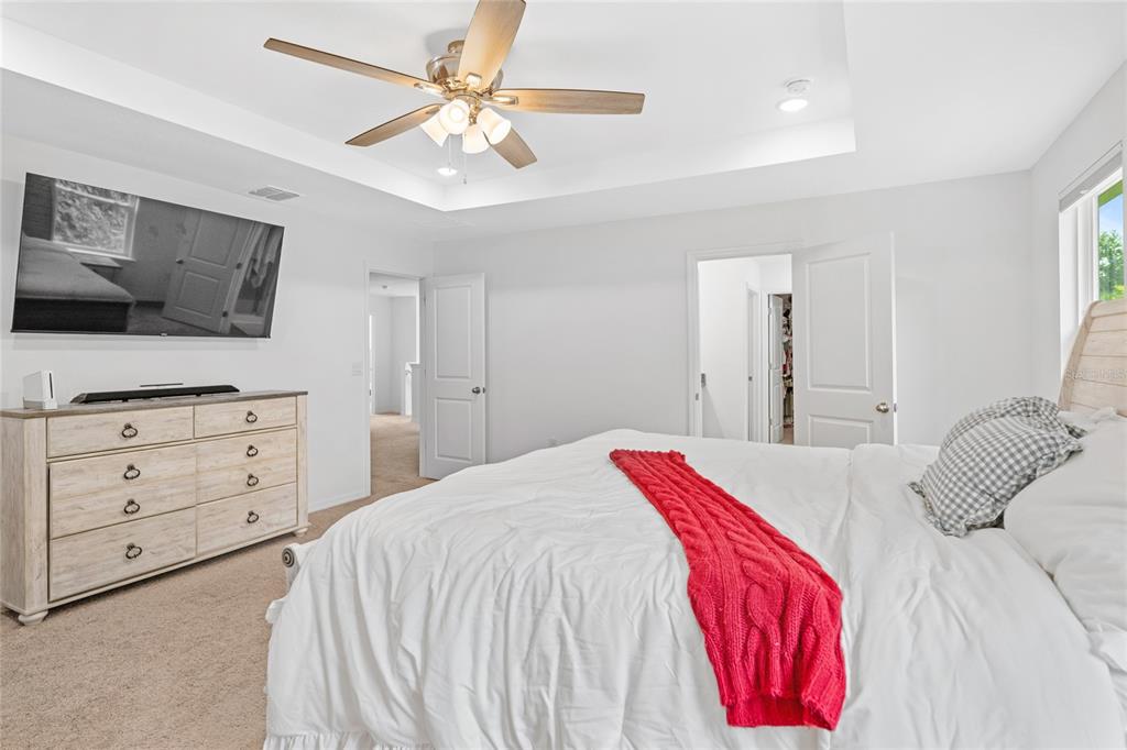 1137 Bradford Rdg Drive Leesburg, FL 34748 - Photo 16 of 37 a bedroom with a bed and a flat screen tv