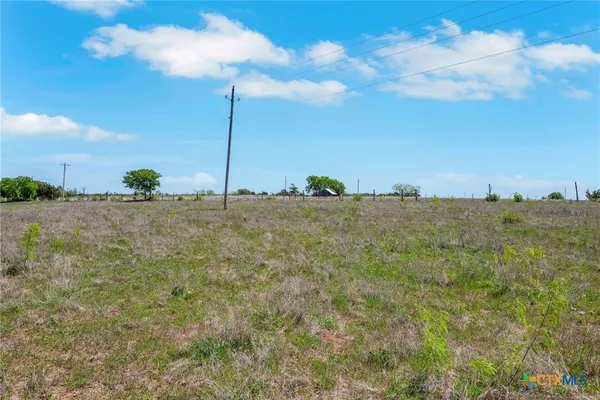 a view of a field with a building in the background