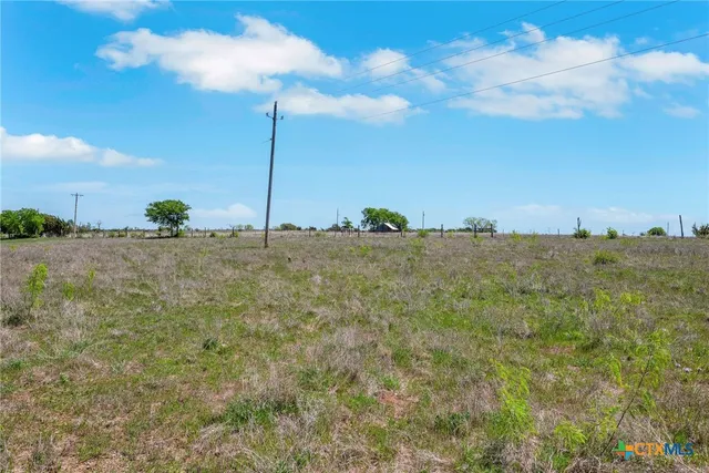 a view of a field with a building in the background