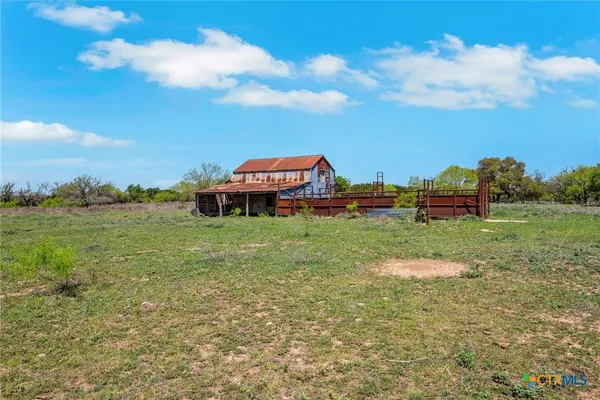 a view of a field with an ocean and trees