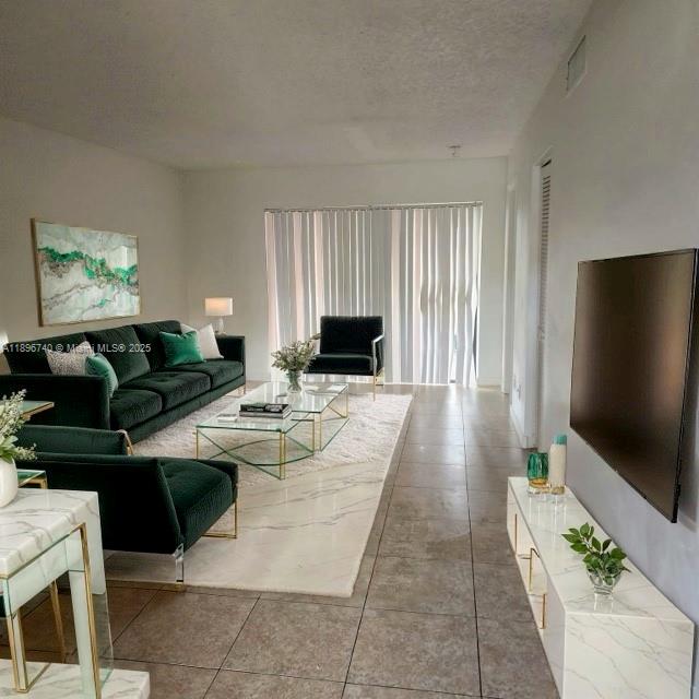 3396 Foxcroft Road, Unit 113 Miramar, FL 33025 - Photo 4 of 10 a living room with furniture and a flat screen tv