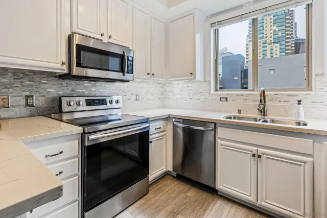a kitchen with stainless steel appliances granite countertop a refrigerator sink and stove