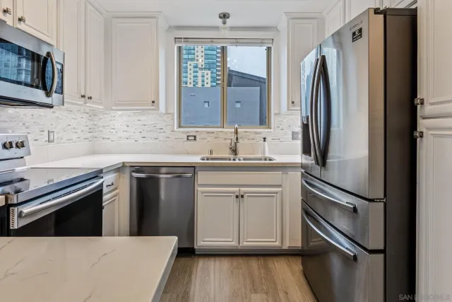 a kitchen with stainless steel appliances a refrigerator sink and cabinets