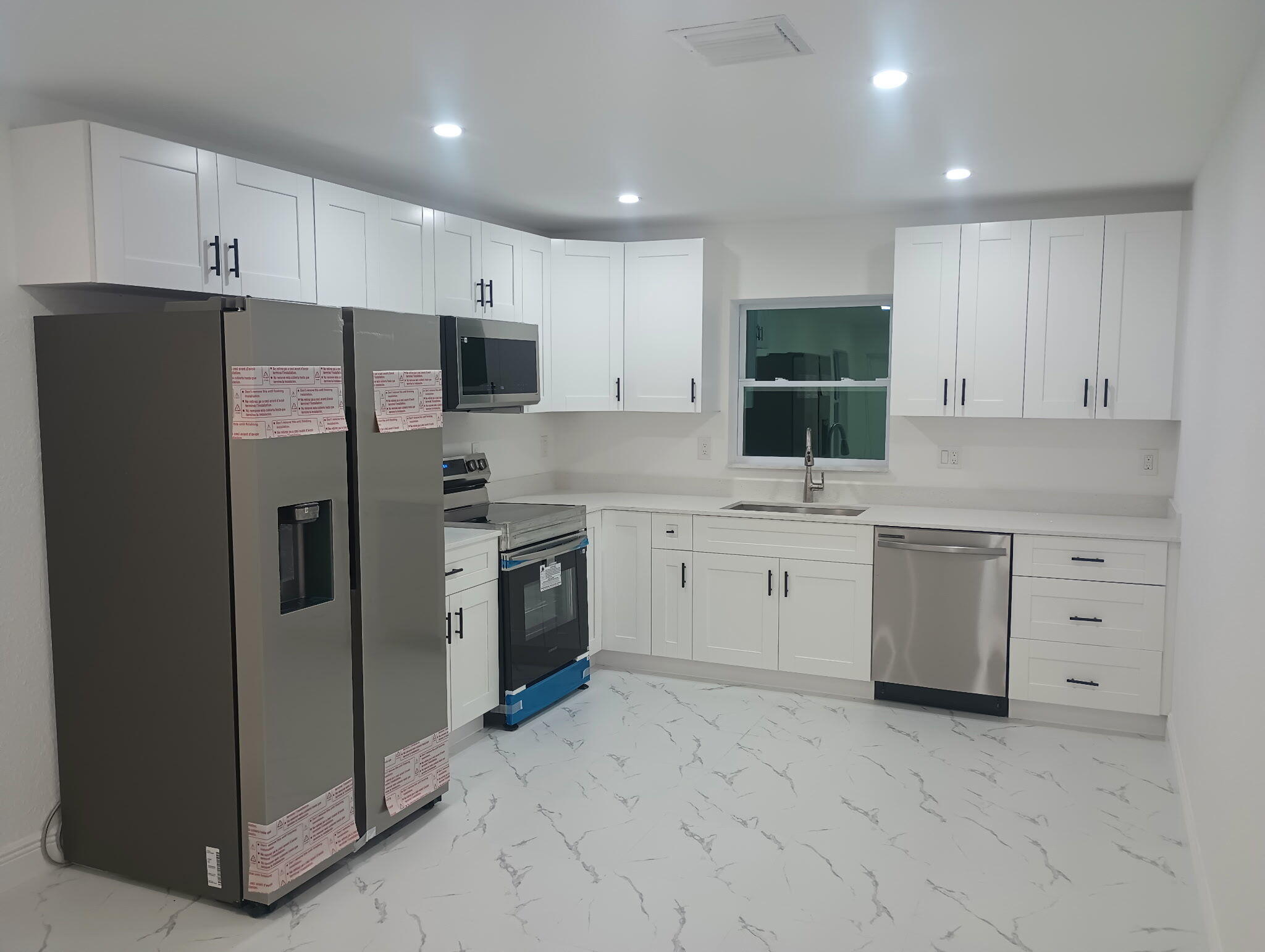 14597 Southwest 170th Avenue Indiantown, FL 34956 - Photo 9 of 31 a kitchen with white cabinets and stainless steel appliances