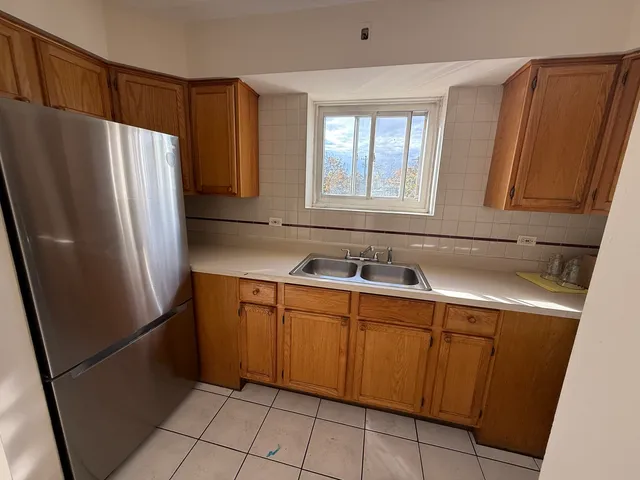 a kitchen with stainless steel appliances granite countertop a refrigerator and a sink
