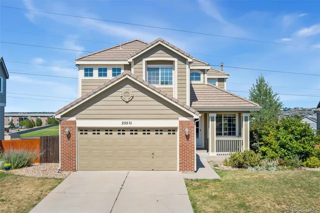 a view of a house with a yard and potted plants