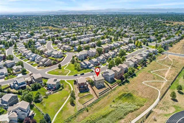 an aerial view of a residential houses with outdoor space and street view