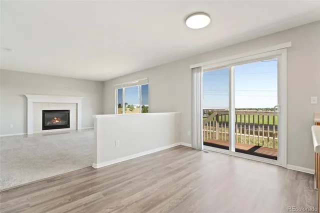 an empty room with wooden floor and fireplace