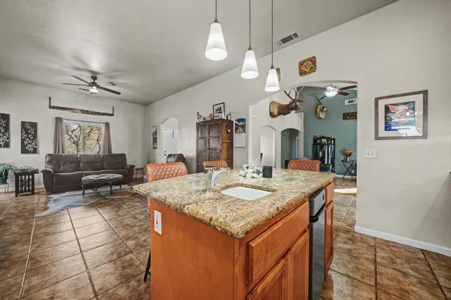 a living room with furniture kitchen view and a wooden floor