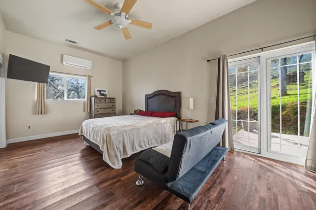 a view of a swimming pool and lounge chairs in back yard of the house