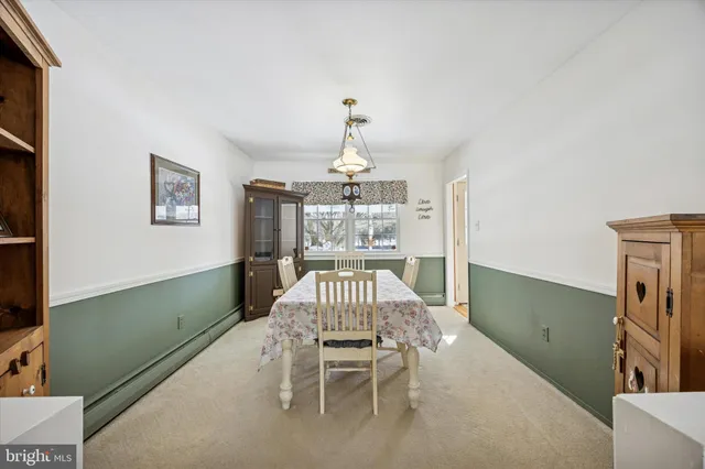 a kitchen with stainless steel appliances granite countertop wooden cabinets a dining table and chairs