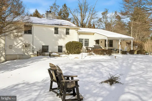 a view of a white house with a yard covered in snow