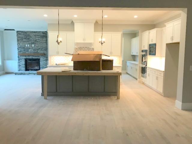 5000 Weatherford Pass, Unit 102 Franklin, TN 37064 - Photo 12 of 29 a large kitchen with stainless steel appliances kitchen island granite countertop a table and chairs