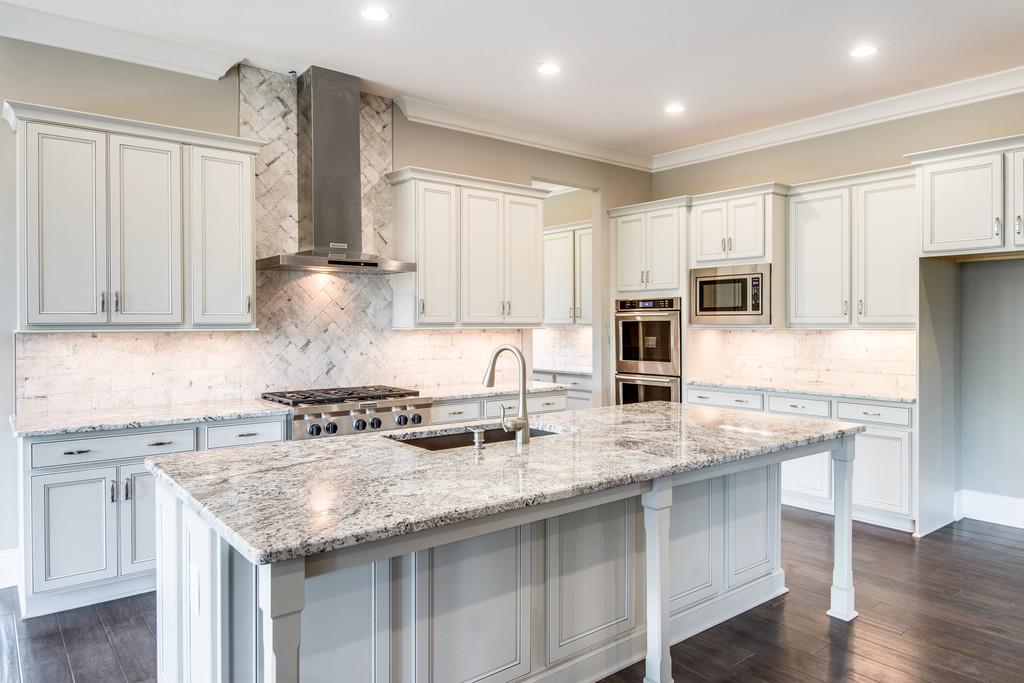 5000 Weatherford Pass, Unit 102 Franklin, TN 37064 - Photo 17 of 29 a kitchen with stainless steel appliances granite countertop a sink stove and refrigerator