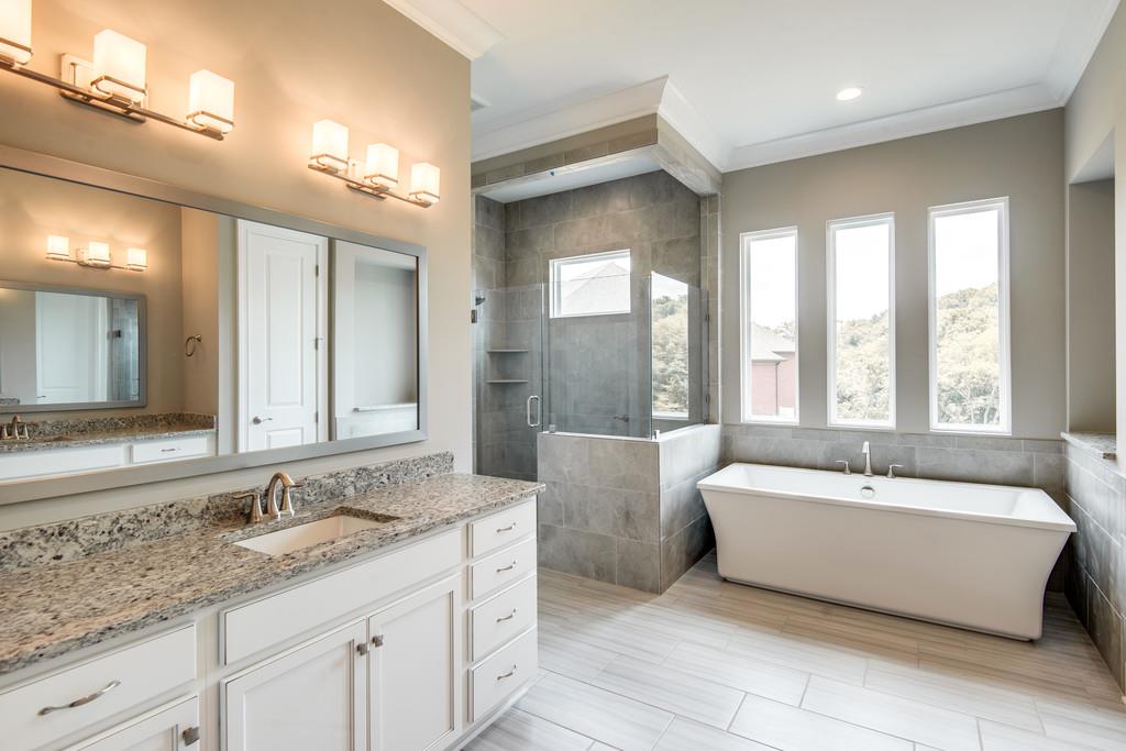 5000 Weatherford Pass, Unit 102 Franklin, TN 37064 - Photo 19 of 29 a bathroom with a tub a double vanity sink large mirror and window