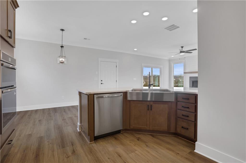 138 Marble Tree Way Ball Ground, GA 30107 - Photo 24 of 65 a kitchen with wooden floors and white cabinets