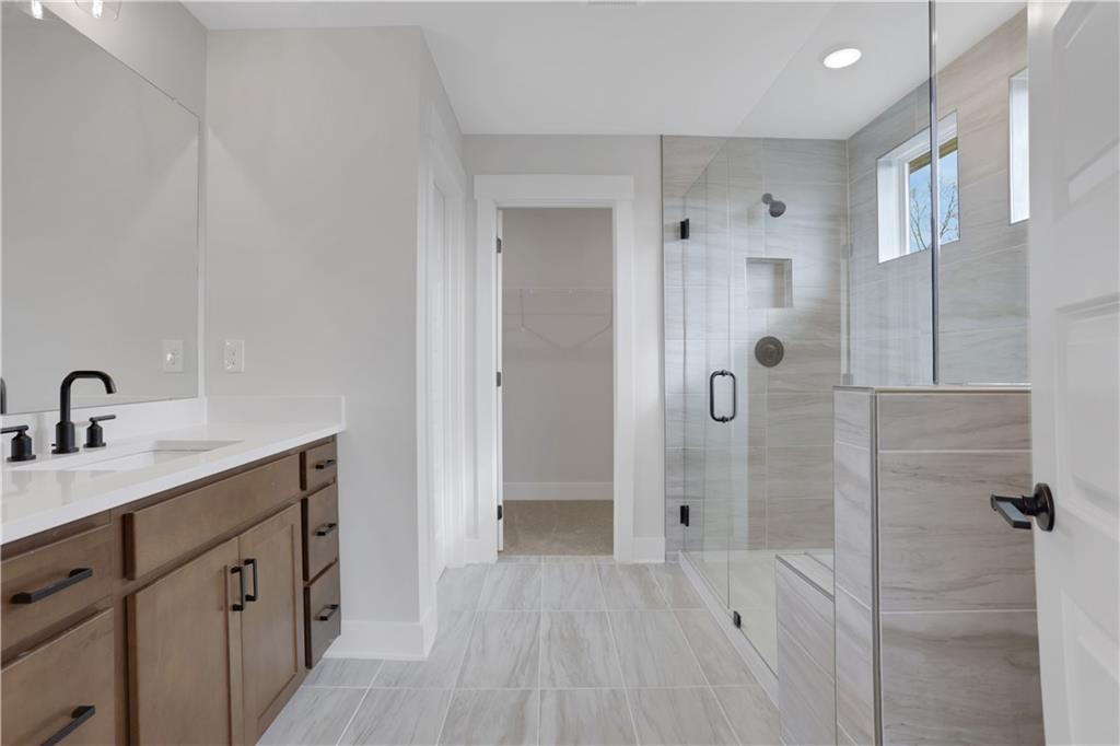 138 Marble Tree Way Ball Ground, GA 30107 - Photo 34 of 65 a spacious bathroom with a shower sink and mirror