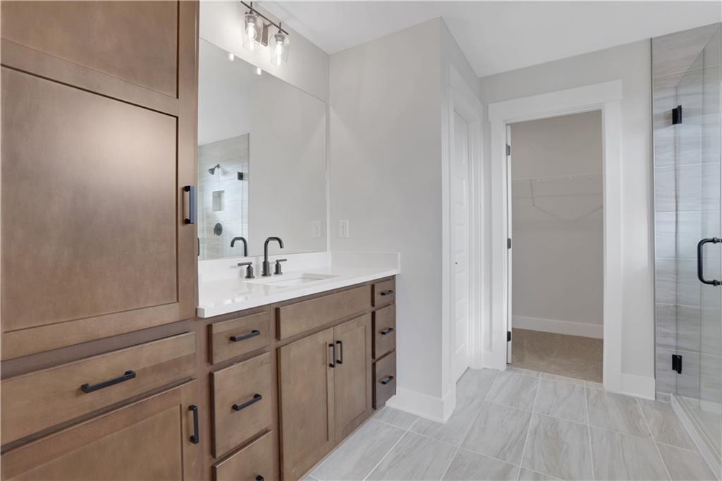138 Marble Tree Way Ball Ground, GA 30107 - Photo 35 of 65 a spacious bathroom with a shower sink and mirror