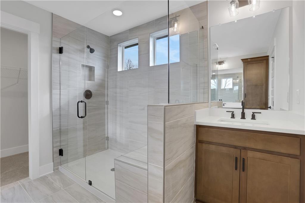 138 Marble Tree Way Ball Ground, GA 30107 - Photo 36 of 65 a bathroom with a shower sink and mirror