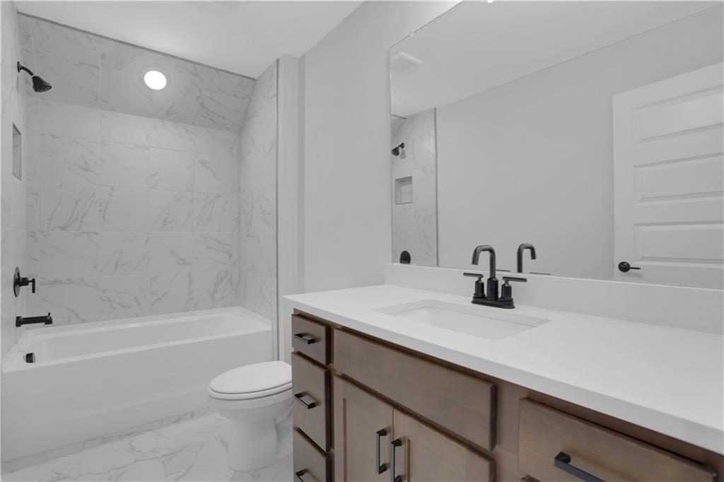 138 Marble Tree Way Ball Ground, GA 30107 - Photo 48 of 65 a bathroom with a sink a toilet and a bathtub