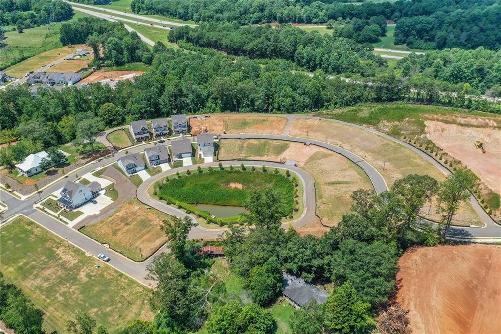 138 Marble Tree Way Ball Ground, GA 30107 - Photo 57 of 65 an aerial view of a house with a yard and lake view