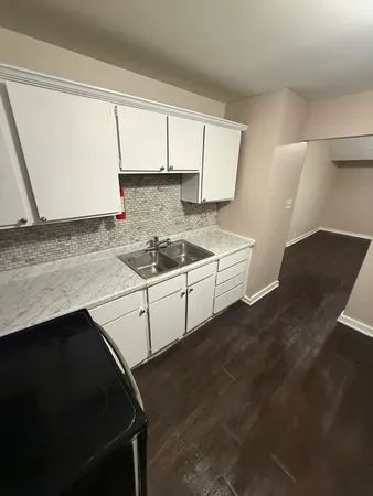 a kitchen with a sink stove and cabinets