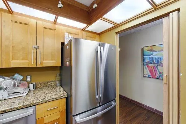 a kitchen with stainless steel appliances granite countertop a refrigerator and a sink