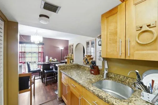 a bathroom with a granite countertop sink a mirror and shower