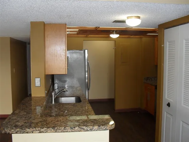 a kitchen with a refrigerator and a wooden floor