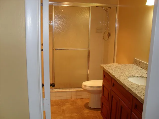 a bathroom with a granite countertop sink toilet and shower