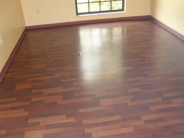 a view of a small space with wooden floor and a window