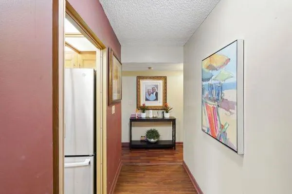 a view of a hallway with wooden floor and windows