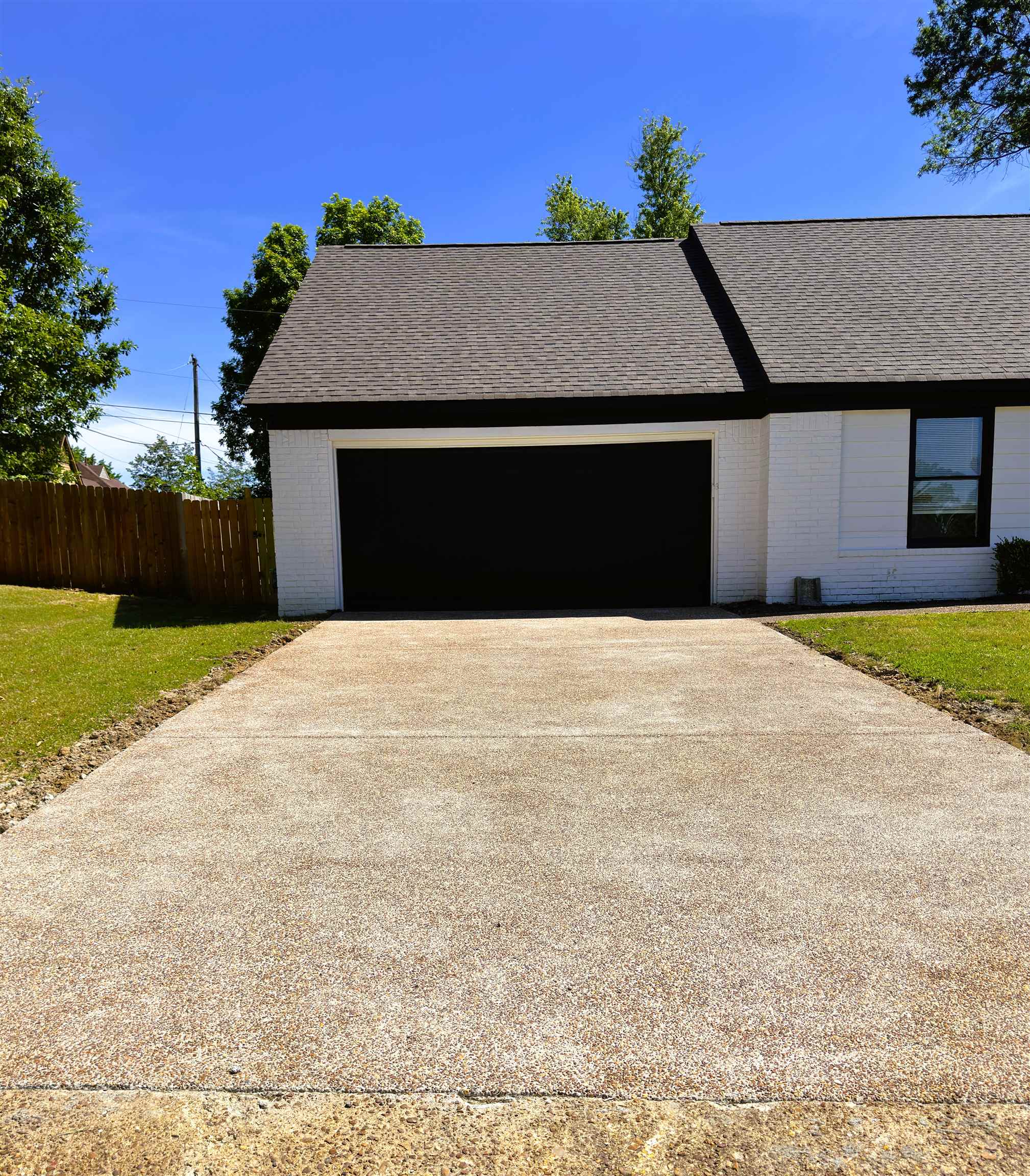 7421 Richmond Road Memphis, TN 38125 - Photo 3 of 39 White brick exterior with a dark shingle roof and contrasting black trim