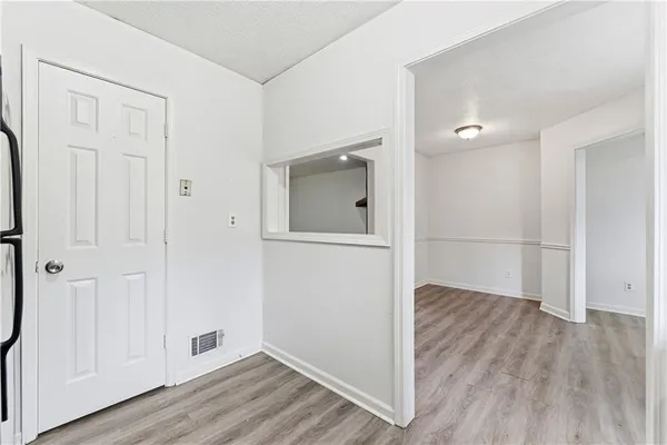 an empty room with wooden floor and mirror