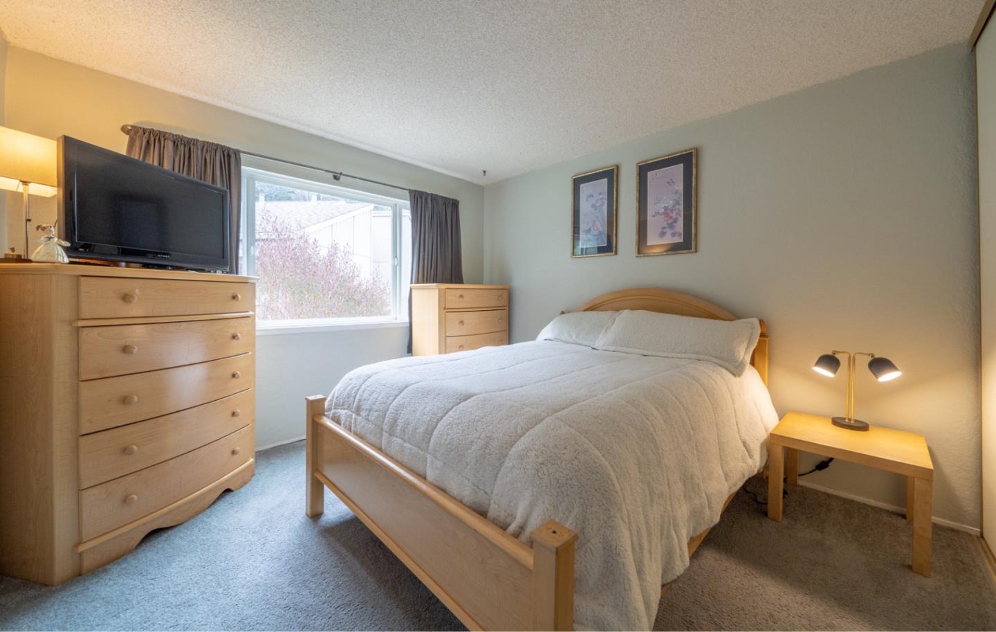 1267 Rosita Road Pacifica, CA 94044 - Photo 15 of 24 a bedroom with a bed and flat screen tv