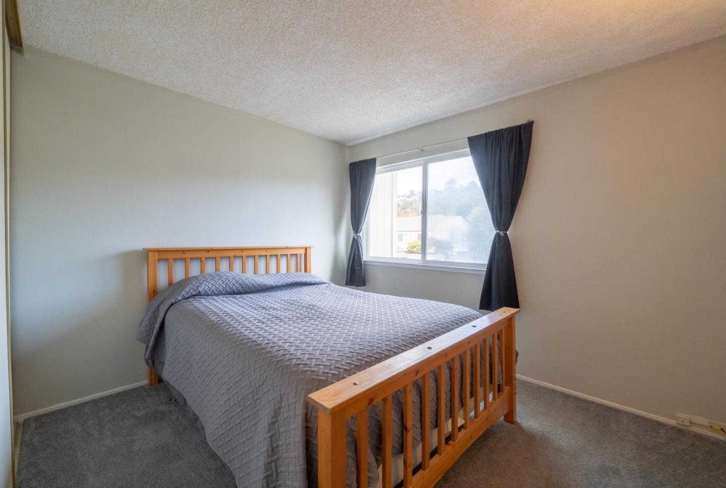 1267 Rosita Road Pacifica, CA 94044 - Photo 18 of 24 a bed sitting in a bedroom next to a window